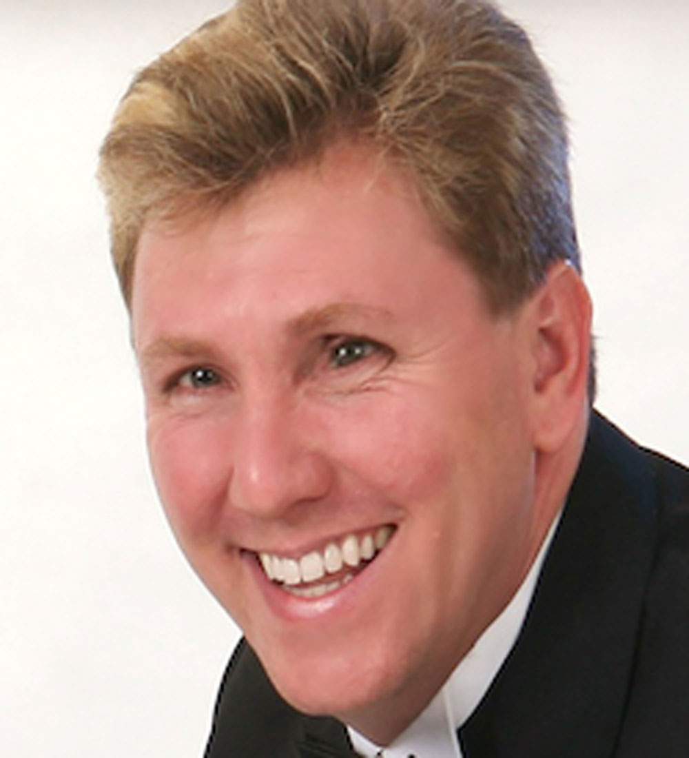 Todd Vigiletti caucasian male with blond hair wearing a black suite and white shirt.